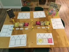 the table is set up with paper cut out houses and other things to make them look like they are made from construction paper