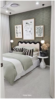 a bedroom with green and white decor in the walls, carpeted flooring and two pictures on the wall above the bed