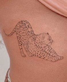 a woman's stomach with a tattoo of a cheetah laying on it