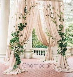 an outdoor ceremony setup with drapes and greenery