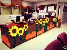 an office decorated for fall with sunflowers and pumpkins painted on the desk