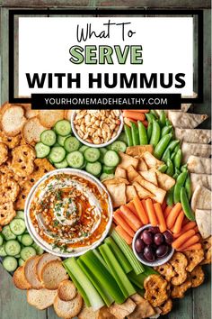 a platter filled with hummus, crackers and vegetables