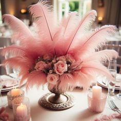 the centerpiece is adorned with pink feathers and roses