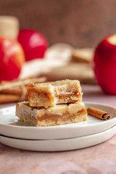 three pieces of apple pie on a plate with cinnamon sticks and apples in the background