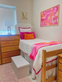 a bedroom with pink and orange decor on the bed, dressers and chest of drawers