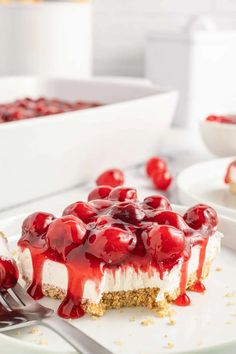 a piece of cheesecake with cherries on it and a fork in the foreground