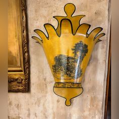 a yellow vase is hanging on the wall