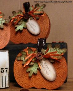 two pumpkins decorated with ribbons and buttons