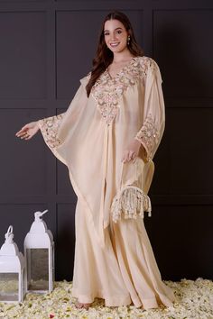 Ivory organza cape jacket with leaf, pearls and seqiuns hand embroidery. Comes with crepe bell bottom and a crop top. - Aza Fashions Embroidered Georgette Kaftan For Wedding, Evening Sharara With Cape Sleeves For Eid, Elegant Chiffon Kaftan For Wedding, Eid Evening Sharara With Cape Sleeves, Silk Abaya For Wedding And Festive Occasions, Festive Silk Abaya For Wedding, Festive Party Abaya In Georgette, Elegant Georgette Kaftan For Reception, Long Sleeve Georgette Kaftan For Wedding