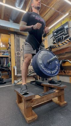 a man standing on a bench with a weight plate