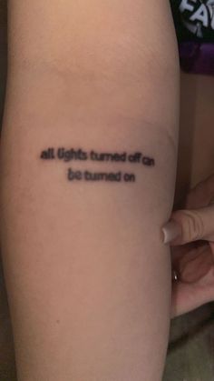 a woman's arm with a tattoo that reads, all lights turned off but turned on