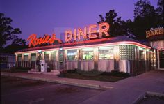 an old diner is lit up at night