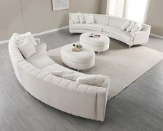 a living room filled with white furniture on top of a hard wood floored floor