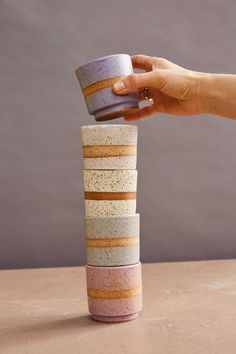 a stack of stacked cups being held by a woman's hand