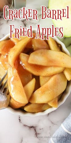 a white bowl filled with sliced apples on top of a marble counter next to a knife and fork