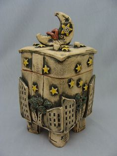 a ceramic box with an owl sitting on it's top and stars around the lid