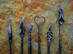 five different types of metal spoons on a rock