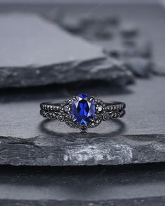 a ring with a blue stone in the center on top of a piece of rock