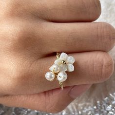 Exquisite handmade Natural freshwater pearl clustered at one end, and cherry blossom shell flower at the other end, twisted with dainty 14K Gold-filled finish. Feminine cute girly vibes, super delicate and elegant! Open and adjustable ring, fit from US size 4 to 10, easy to wear and stacking. Add some spice to your everyday/occasions/bridal or bridesmaid look, be the shiniest one easily, perfect gifts idea for yourself and your loved ones :) ♥ All of our jewelry are carefully handmade with delicate and exquisite details, all designed and made in Manhattan, New York. 💎 Features: ♥ Made to Order ♥ Material: 14K Gold Filled ♥ Main stone: Natural freshwater pearl ♥ Open adjustable size 💎 Details: ♥ Approximate Measurements: - flower length: 0.25" width: 0.25" - pearl cluster length: 0.25" wi Flower Shaped Pearl Ring For Wedding, White Mother Of Pearl Wedding Ring, Delicate White Flower Ring, Delicate Pearl Flower Jewelry, Dainty Handmade Pearl Open Ring, Handmade Dainty Pearl Open Ring, Dainty Pearl Open Ring, Delicate Pearl Open Ring, Delicate Pearl Drop Open Ring