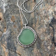 This beautiful piece of Sea Green Sea Glass was found on the French side of the beautiful island of Saint Martin. The bezel is wrapped with hand twisted wire. There is a sold back plate on the pendant. 925 Sterling silver and fine silver was use to create this pendant. 20" Snake Chain included Photos are taken outside in sunlight and shaded areas to show the way the light shines differently on the sea glass. (Today's photos are on a cloudy day) Silver Sea Glass Necklace With Wire Wrapped Detail, Wire Wrapped Silver Necklace With Sea Glass, Wire Wrapped Silver Sea Glass Necklaces, Silver Sea Glass Round Pendant Jewelry, Handmade Sea Glass Pendant Jewelry, Silver Wire Wrapped Jewelry For Beach, Sterling Silver Hand Wrapped Necklace, Hand Wrapped Sterling Silver Round Necklace, Hand Wrapped Sterling Silver Necklace