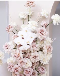 a vase filled with lots of white and pink flowers