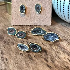 three pieces of agate stone sitting on top of a wooden table next to a vase