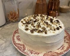 a cake with white frosting and toppings on a plate