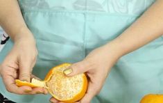 a woman peeling an orange into pieces with one hand and the other in her other