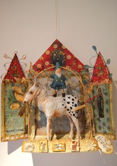 a small figurine is hanging on the wall next to a cow and other decorations