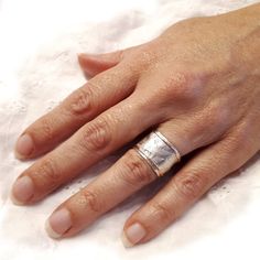 a woman's hand with two silver rings on top of her left and right hand