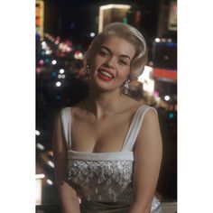 marilyn monroe posing in front of the las vegas strip at night, wearing an evening gown