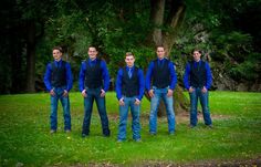 a group of men standing next to each other on top of a lush green field