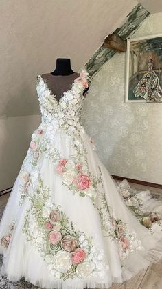 a white wedding dress with pink flowers on it