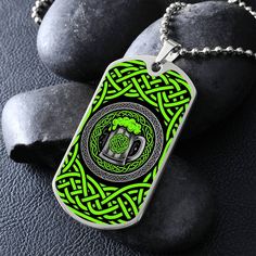 a green and black dog tag sitting on top of some rocks