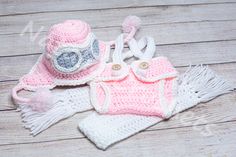 a crocheted hat, diaper and booties are laying on a wooden surface