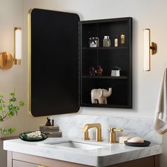 a bathroom sink with gold faucets and marble counter top next to a black cabinet