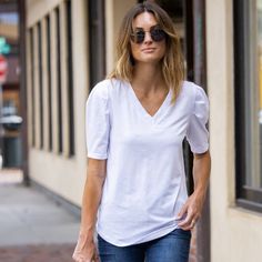 Introducing the Amaryllis Women's V-Neck Puff Sleeve Tee, where casual meets elegance. This tee features a flattering V-neckline that enhances the neckline, while the puff sleeves with gathered shoulder detail add a stylish and feminine touch. Made from soft stretch fabric, this tee provides comfort and ease of movement, making it an ideal choice for everyday wear. The relaxed fit ensures it pairs effortlessly with jeans or skirts for a versatile look. Whether you're running errands or meeting f Lace Tee, Elbow Sleeve, Front Tie Top, Scalloped Lace, Crop Tshirt, Puff Sleeves, Running Errands, Shirt Shop, Neck T Shirt