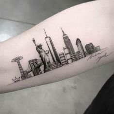 the statue of liberty tattoo on the left arm is shown in black and grey ink