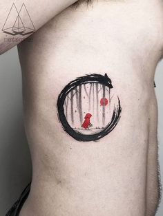 a man's chest with a red bird and black circle tattoo on his left side