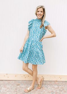 Nothing is going to make you quiet as happy this spring as slipping into the Blue Bonnet Dress!

Mint green with blue floral.
Mock neck with a ruffle. 
Ruffle cap sleeve. 
Lined. 
Polyester.
 This dress is a classic! We love the mint green background with pop of bright blue flowers, so perfect for spring. Plus, how chic is that ruffle mock neck and cap sleeve. It was love at first sight for us and we are sure it will be for you too! Casual Cap Sleeve Dress With Ruffles, Spring Green Cap Sleeve Dress, Green Cap Sleeve Spring Dress, Green Cap Sleeve Dress For Spring, Green Cotton Dress With Ruffle Sleeves, Light Blue Ruffle Sleeve Dress For Spring, Spring Outfits 2020, Dress Mint Green, Blue Bonnet