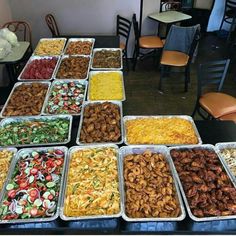 a table topped with lots of trays of food