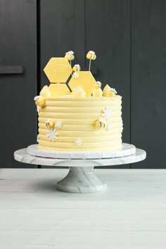 Een vrolijke gele botercreme taart, afgestreken met een bubble scraper om het idee van een bijenkorf te geven.  de kleine bijen zijn gemaakt van fondant, en ook de zeshoekjes waarmee ik een soort topper maakte.   de witte madeliefjes geven het een leuk zomers thema. perfecte taart voor een (hobby) imker of een 1-jarige als je een Bee One thema wilt. Bees Cake Ideas, Bumble Bee First Birthday Girl, Bee Cake Ideas 1st Birthdays, Bride To Bee Cake, Bee Smash Cake, Bee Theme Cake, Bee Day Cake, Honey Bee Cake, Bee Hive Cake