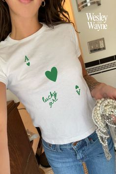 "Looking for a graphic baby tee nostalgic of the 90s? Bring your Y2K outfit dreams to life with our newest St. Patty's Day collection☘️ This classic baby tee will fit like a well-loved favorite from its first wear. Our stylish Gildan 5000B tees feature...  100% USA cotton (Note: Sports Gray color variation features 90% Cotton & 10% Polyester)  Ribbed knit, crew neckline and tear away label  90s style baby tee fit - please reference our size chart for details ✨ PLEASE NOTE: The Gildan 5000B is a \"youth\" t-shirt. Reflective of authentic baby tees of the 90s, the shirt will hit at hip length and may feel looser around the waist than at the bust. Unlike today's crop tops, these are not designed to feel skin tight.  👉🏼 The listing photos reflect the Gildan 5000B garment on a female model wi 90s Shirts Graphic Tees, Minimal Shirt Design, Lucky Girl Syndrome, Coquette Shirt, Baby Graphic Tees, Lucky Shirt, 90s Baby, Y2k Baby Tee, Downtown Girl