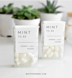 mini to be candy bar wrappers sitting on a table next to potted plants