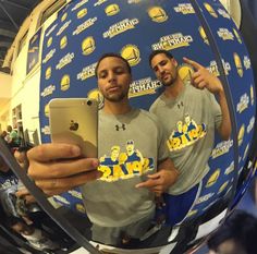 two men are taking a selfie in front of a mirror with the golden state warriors on it