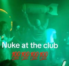 a group of people standing around in front of a green background with the words nuke at the club