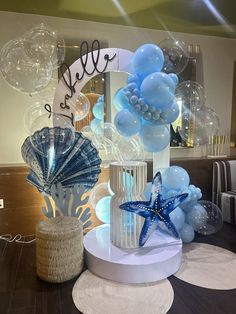 balloons and starfishs are on display in front of a mirror