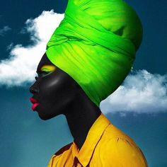 an image of a woman wearing a green turban on her head with clouds in the background