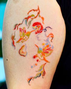 a woman's arm with colorful tattoos on it