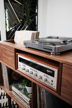 a record player is sitting on top of a shelf